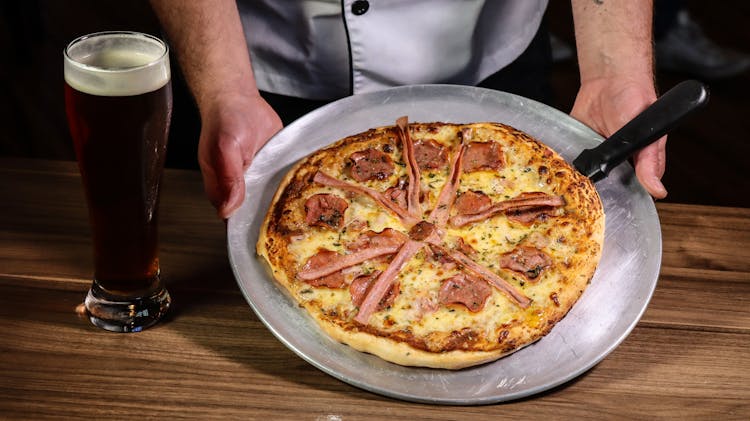 Whole Pizza Beside A Glass Of Beer