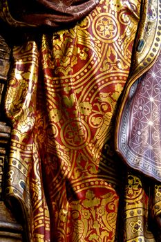 Detailed close-up of ornate Renaissance fabric with gold floral patterns and rich textures.