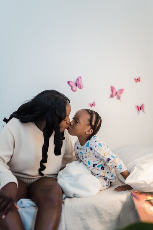 Mother Kissing Daughter in Bed