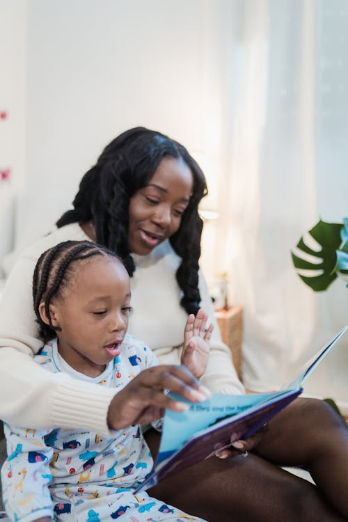 Free Mother Reading a Bedtime Story to Her Son  Stock Photo