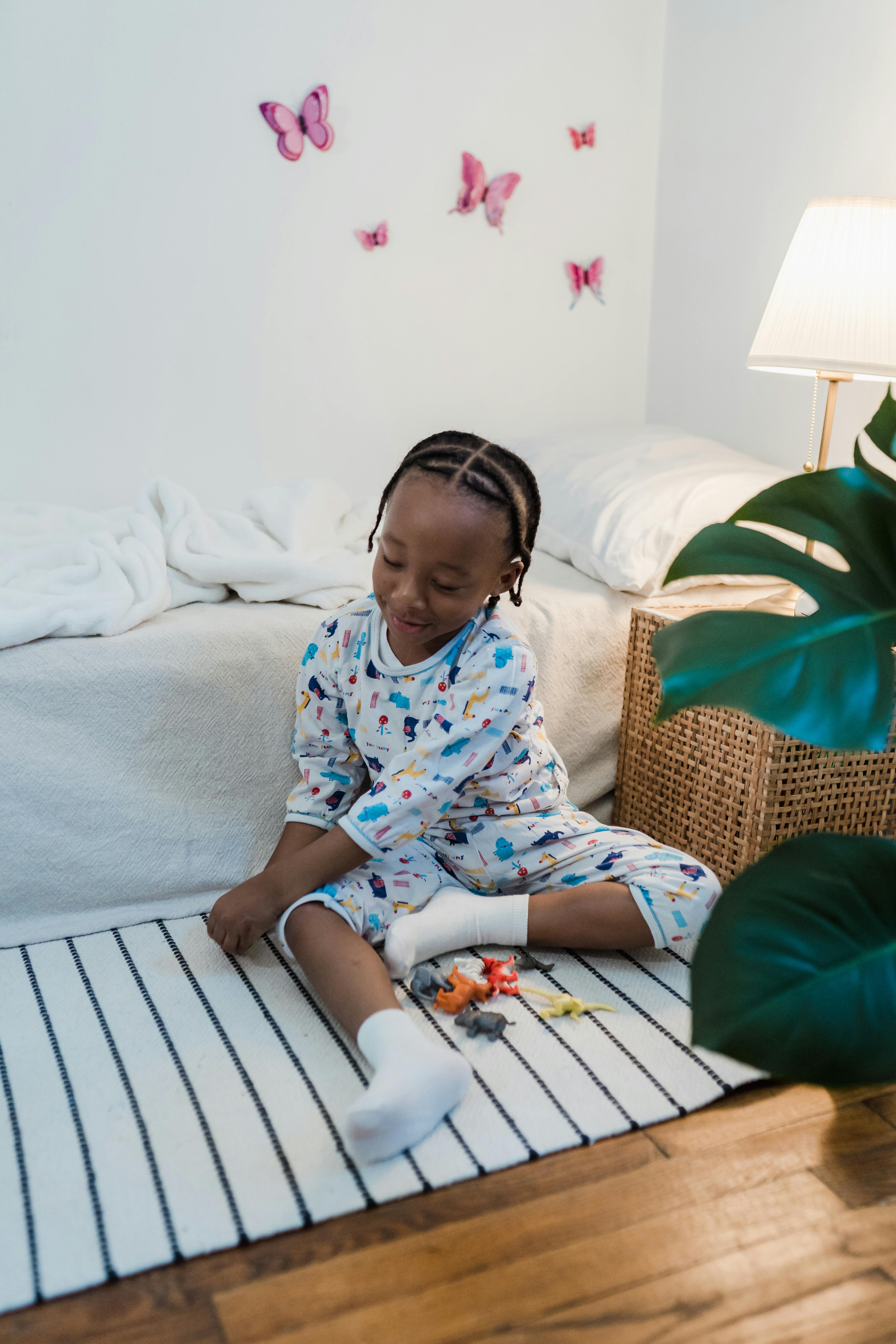 little boy in pajamas playing with his toys in his room