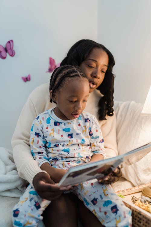 Free Mother Reading a Bedtime Story to Her Son  Stock Photo