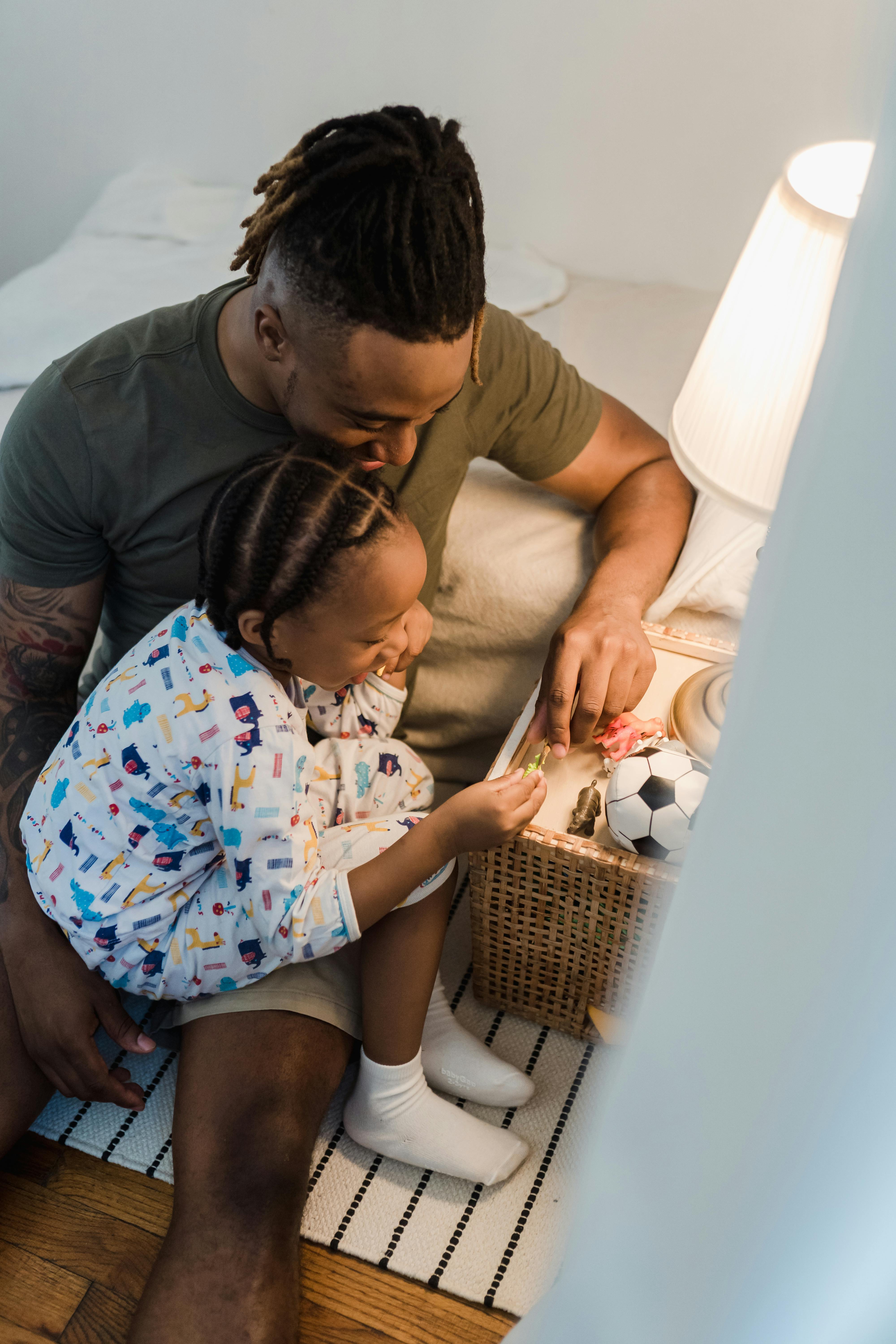 A father and daughter share a tender moment in a cozy bedroom setting, enhancing home warmth.