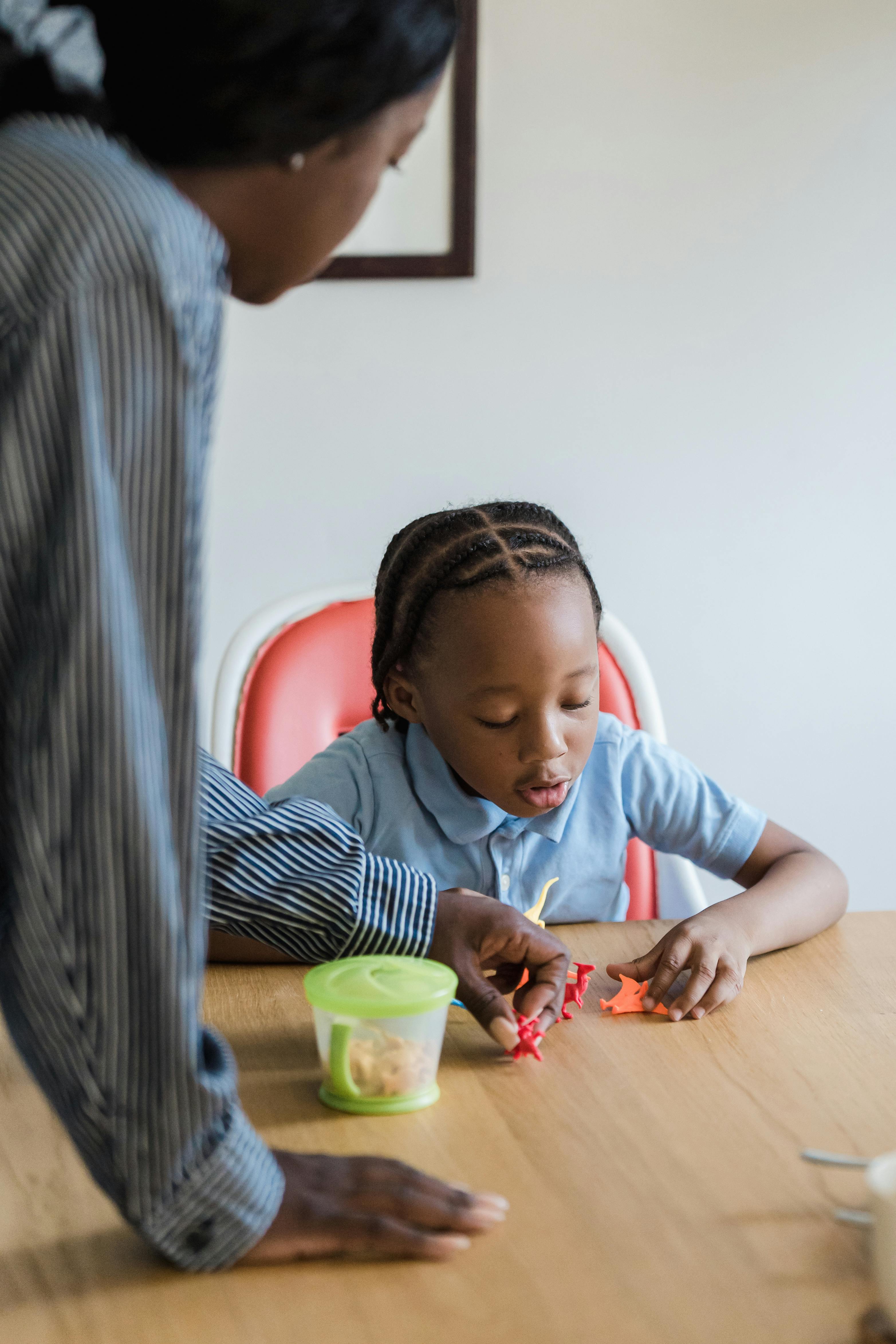 mother and daughter playing with toys a table