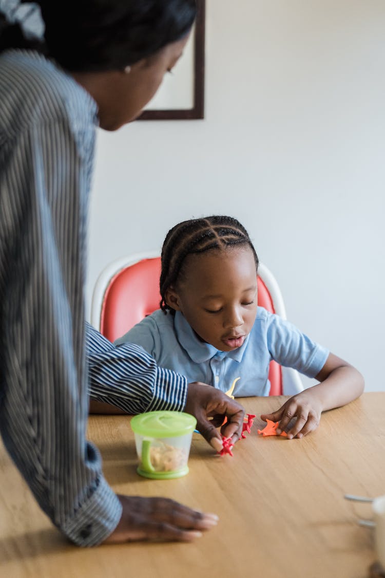 Mother And Daughter Playing With Toys A Table