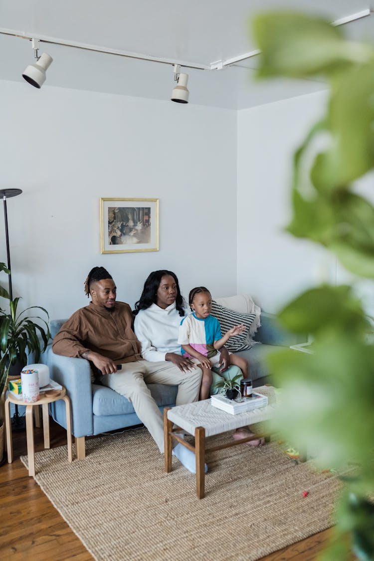 Parents Watching TV With Son In A Living Room