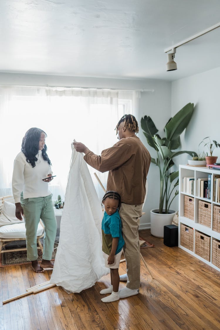 Family With Kid Building Tent At Home