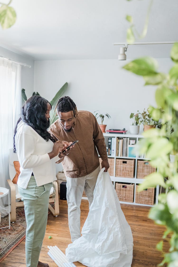 Young Parents Building Indoor Tent At Home 