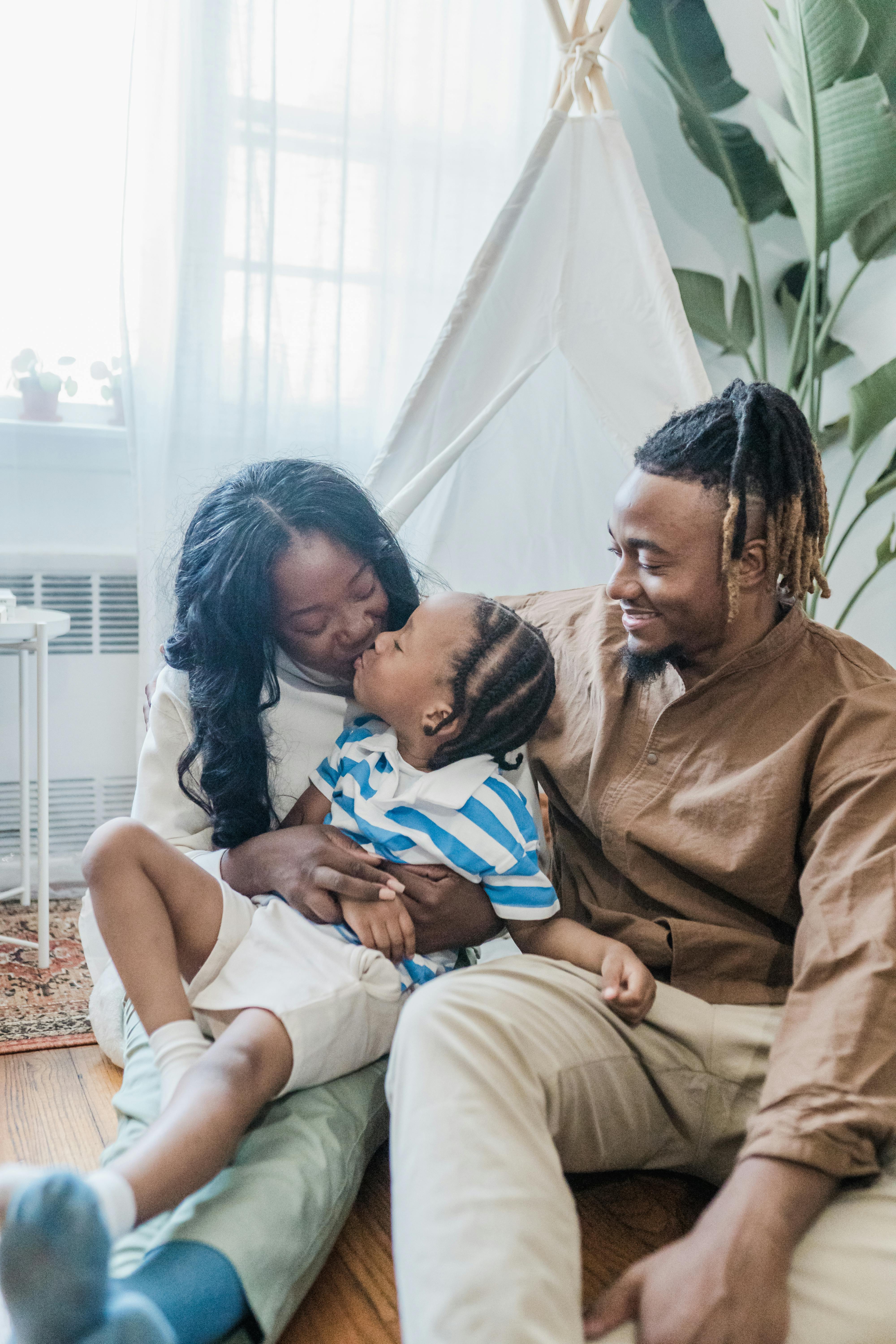 family in a living room son kissing mother