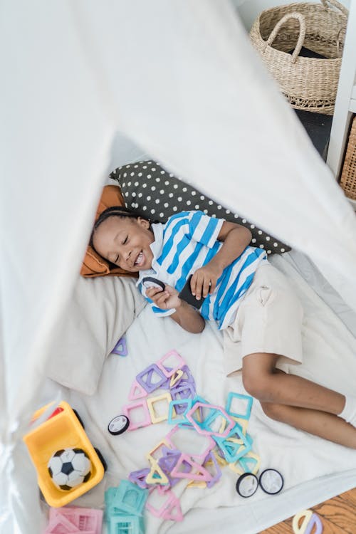 Free Little Boy in Playing with His Toys in a Teepee Stock Photo