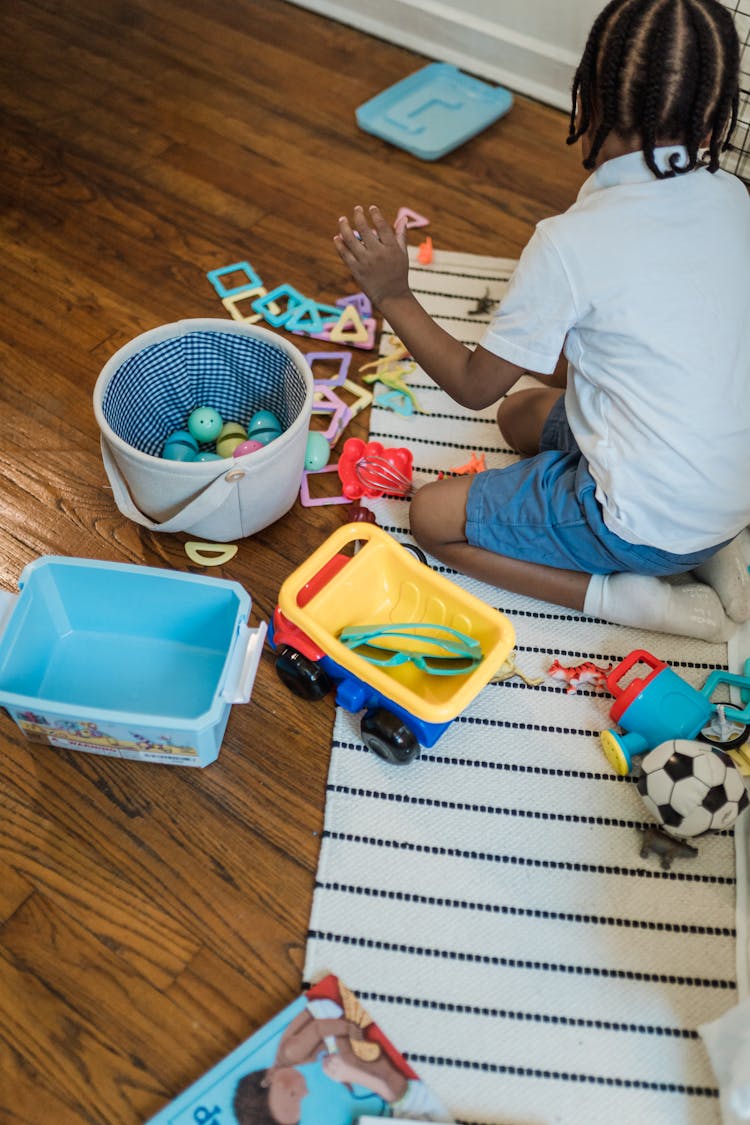 Boy Playing With Toys On A Floor 