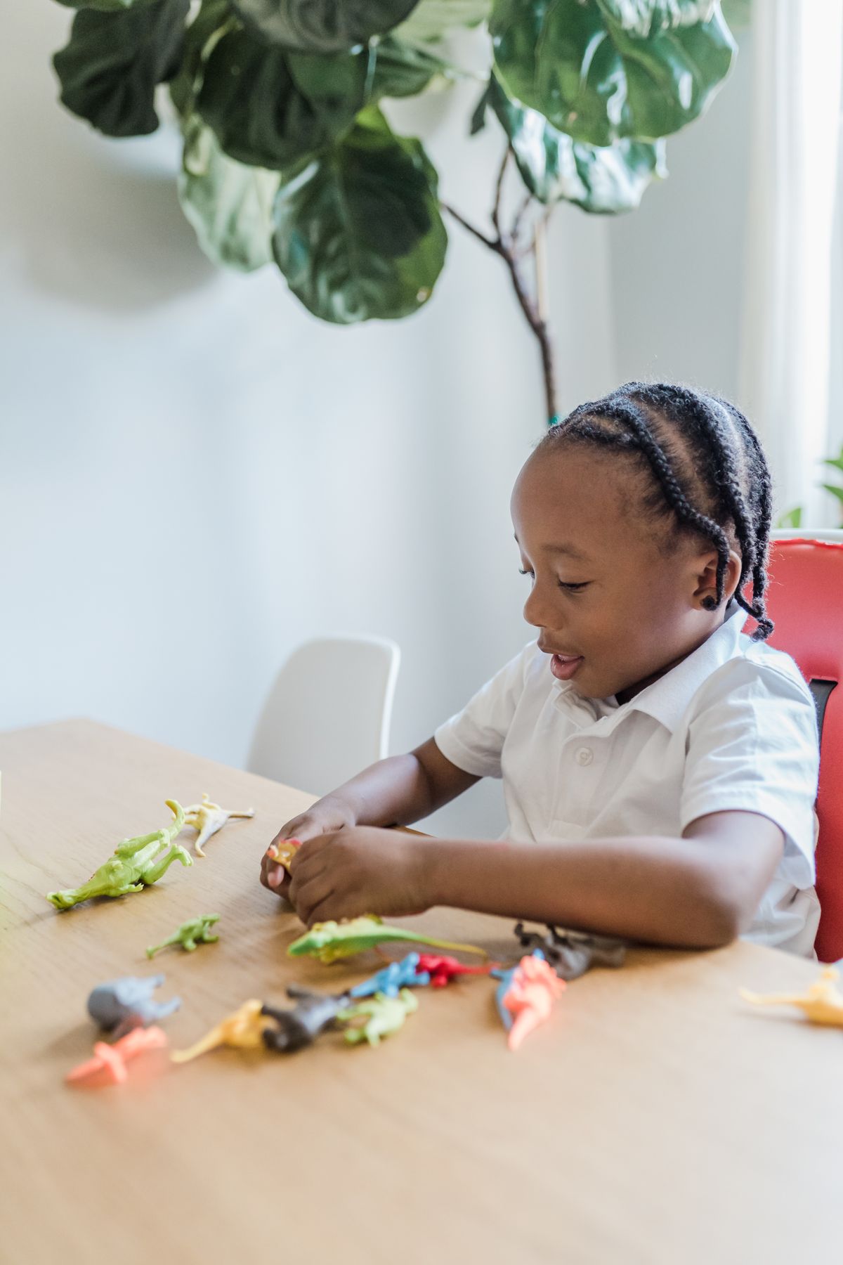 Little girl playing with toy dinosaurs for dinosaur crafts for kids