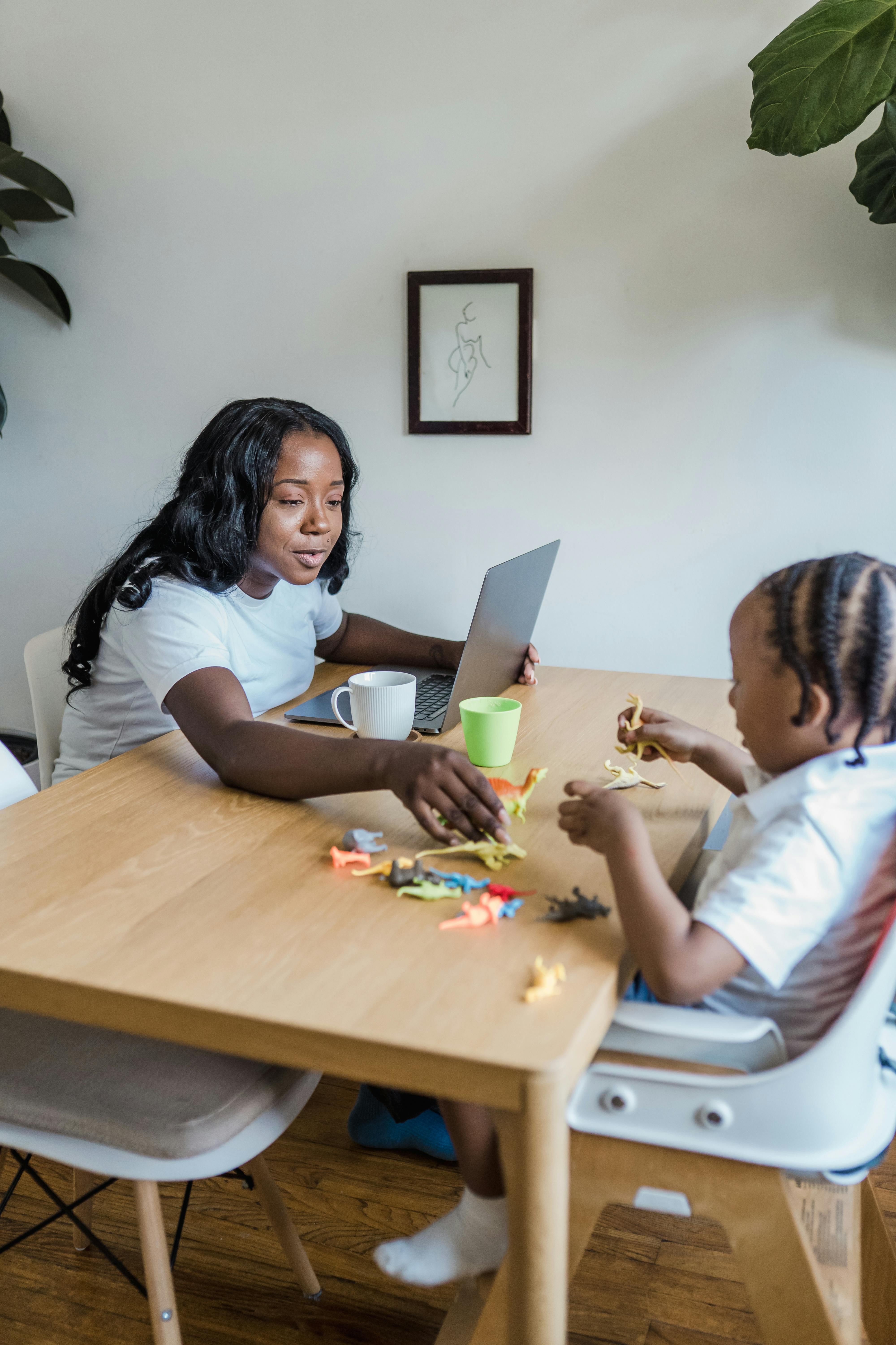 mother playing with child sitting at table