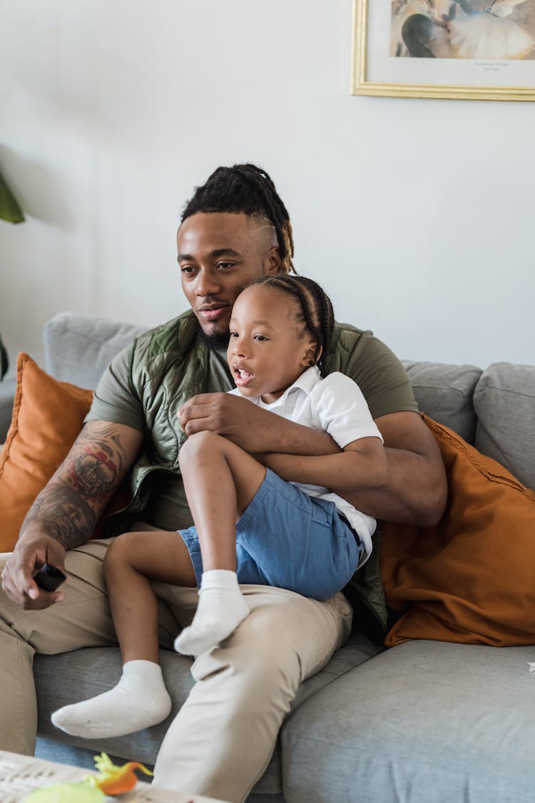 Father And Son Relaxing On Couch At Home