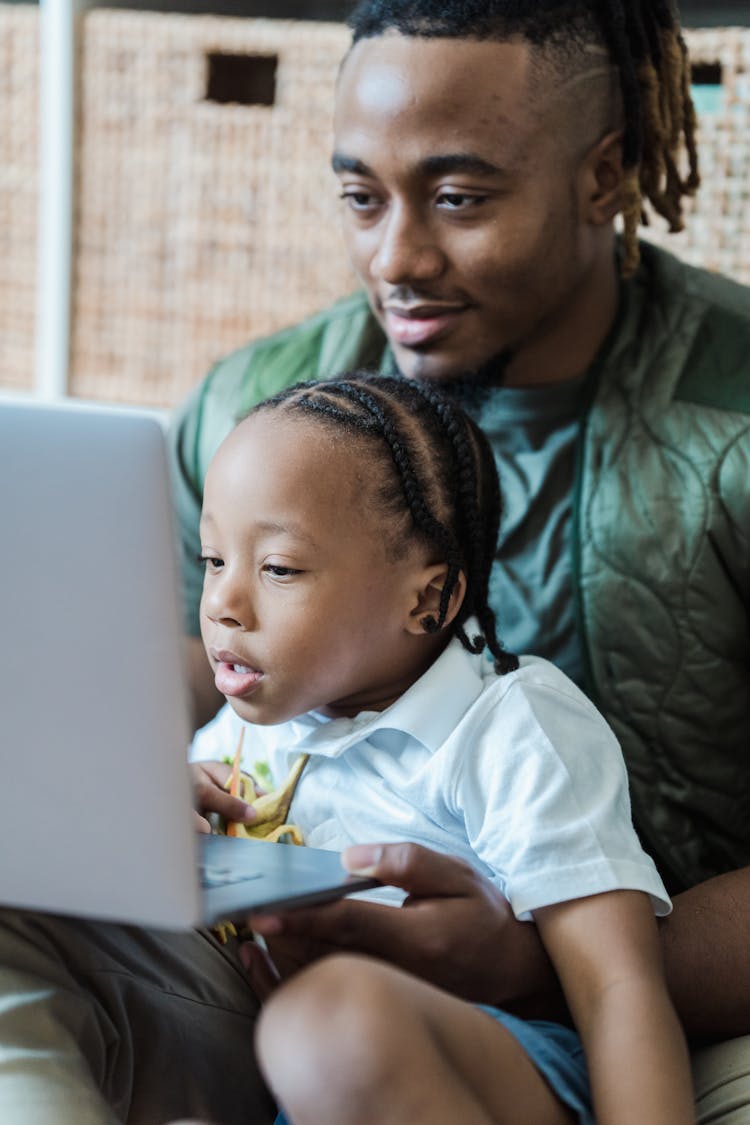 Father And Daughter Working On Laptop Together