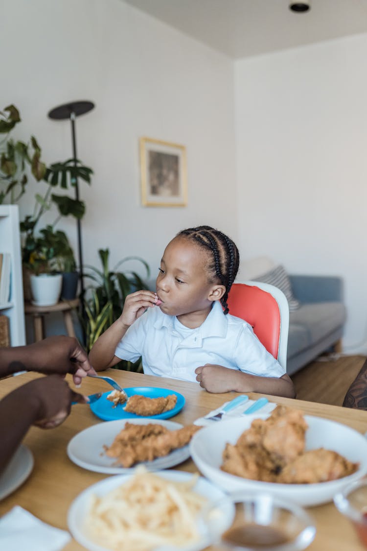 Little Girl Eating Dinner With Fingers