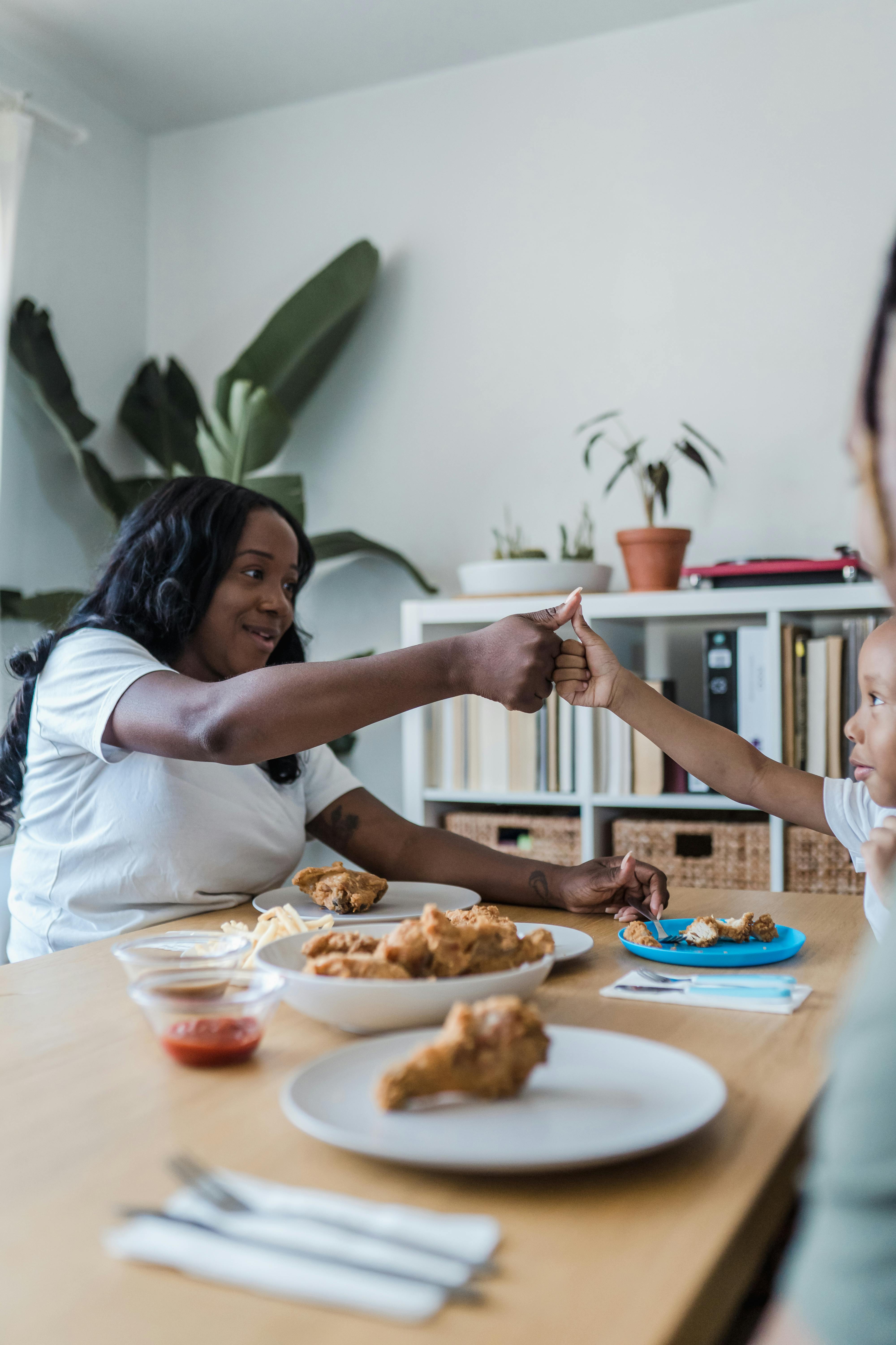 mother and child playing eating at table