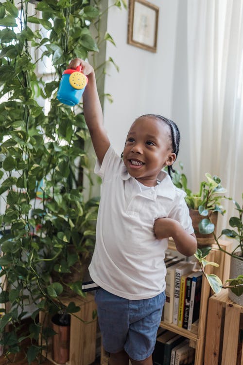 Happy Small Boy Playing with Toy Watering Can