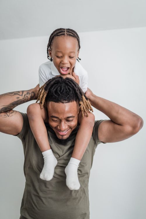 Free A joyful father gives his daughter a piggyback ride, capturing their close bond and happiness. Stock Photo