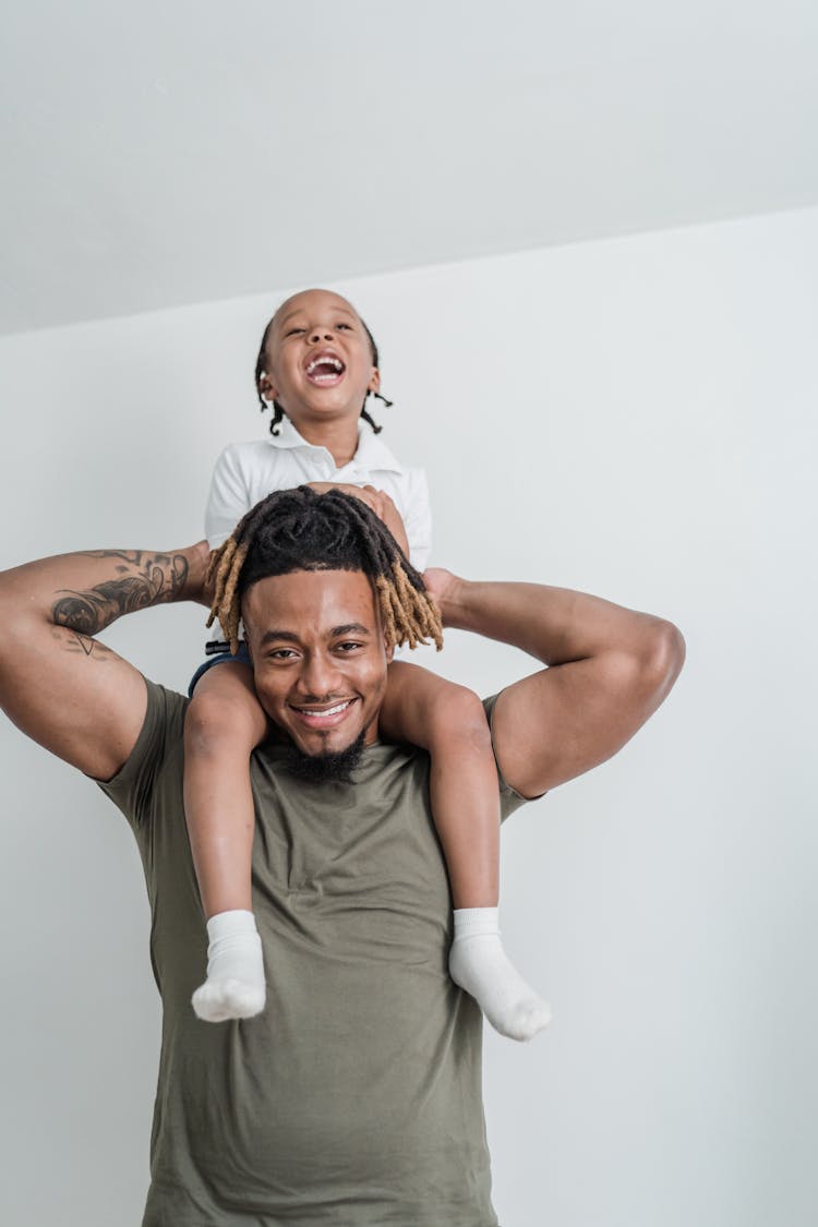 Happy Daughter Sitting On Father Shoulders