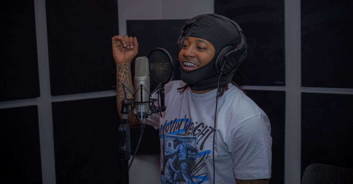 Pastor Prince D in a candid studio session, smiling while adjusting headphones