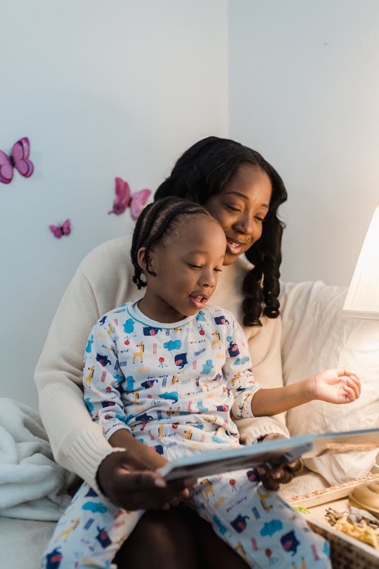 Mother Reading A Book To Her Son At Night 