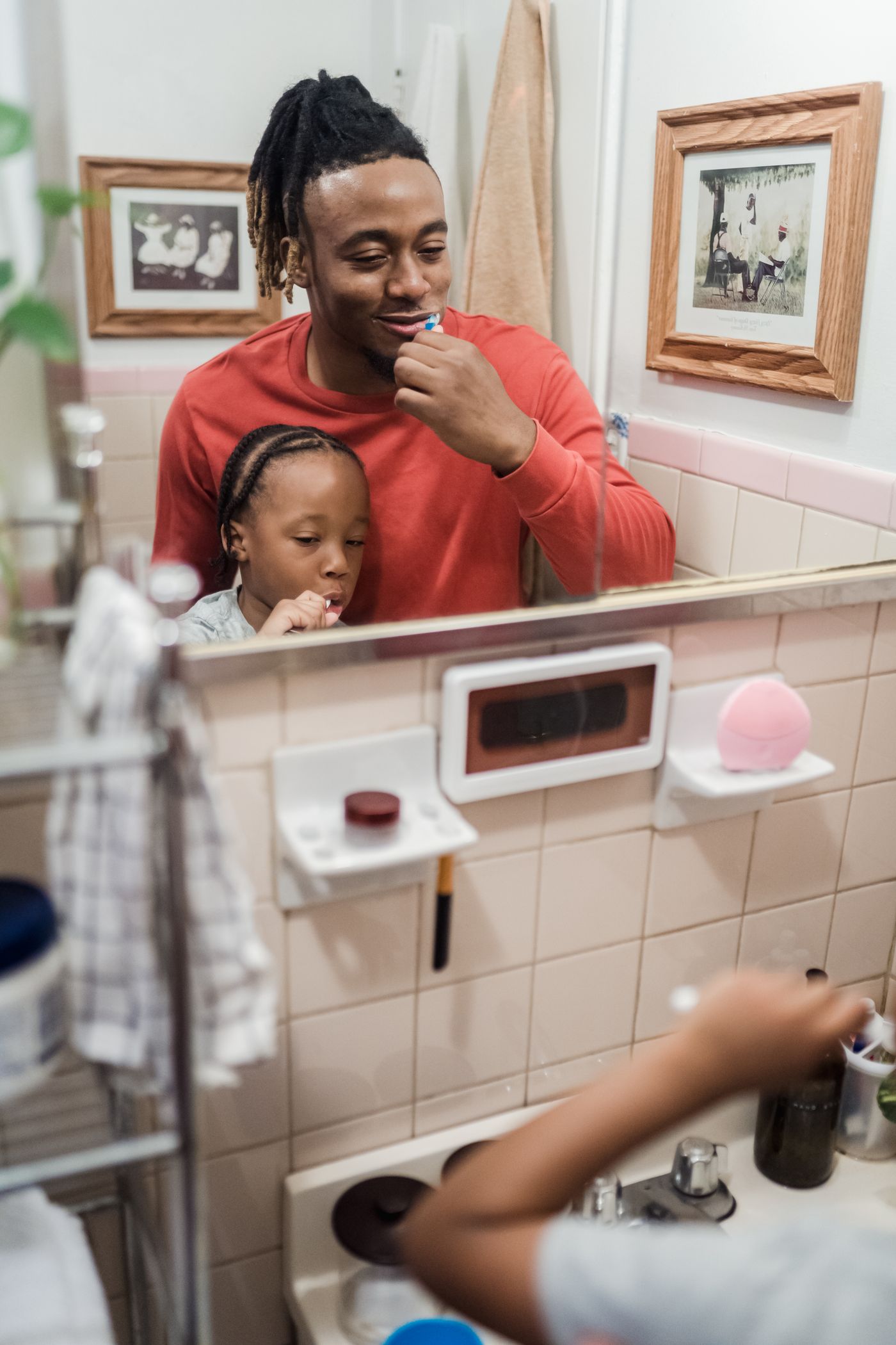Father and daughter brushing their teeth together during a bright family oral care routine