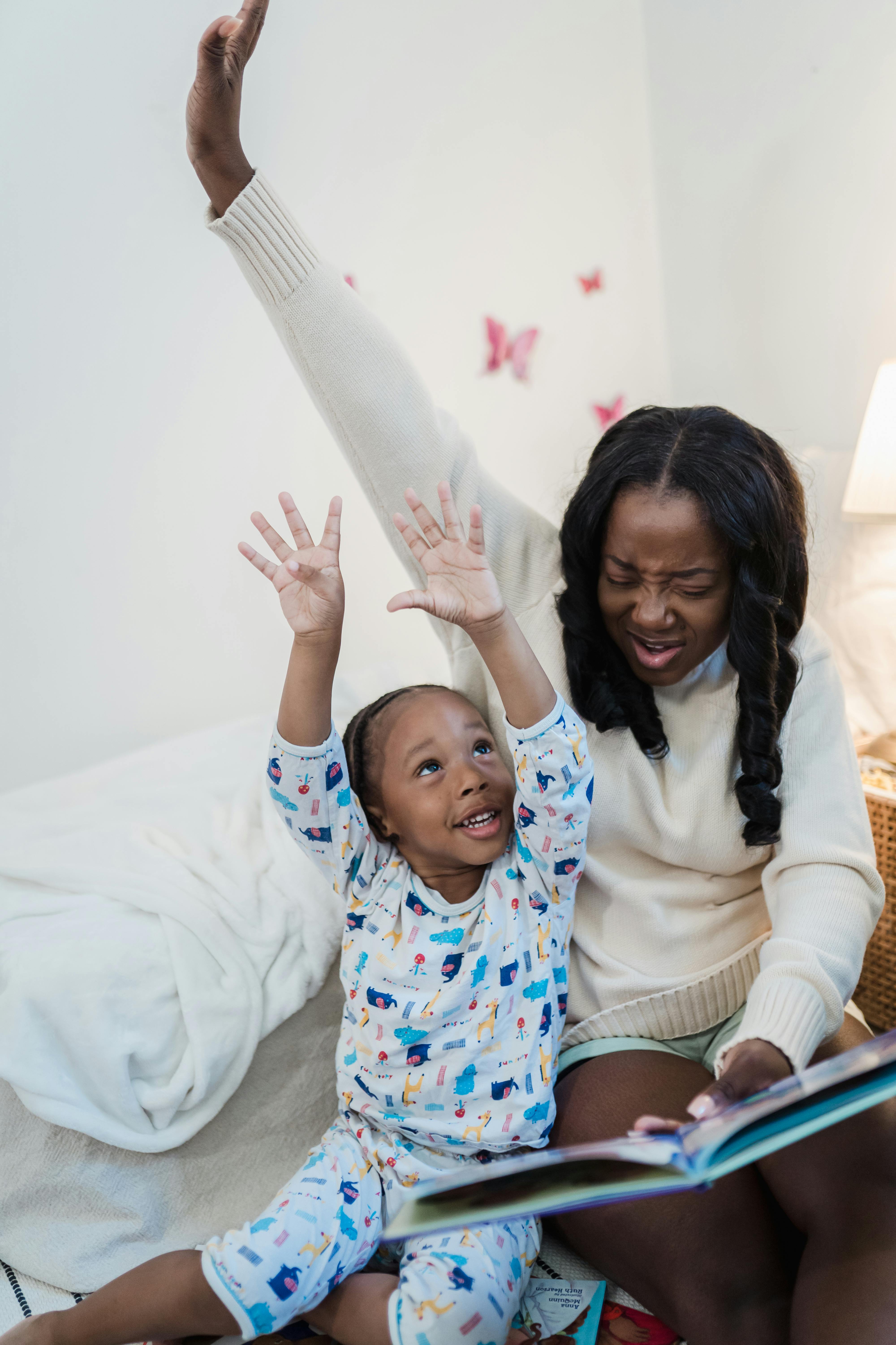 A joyful mother and child bonding while reading a book in a cozy bedroom setting, emphasizing family love and happiness.