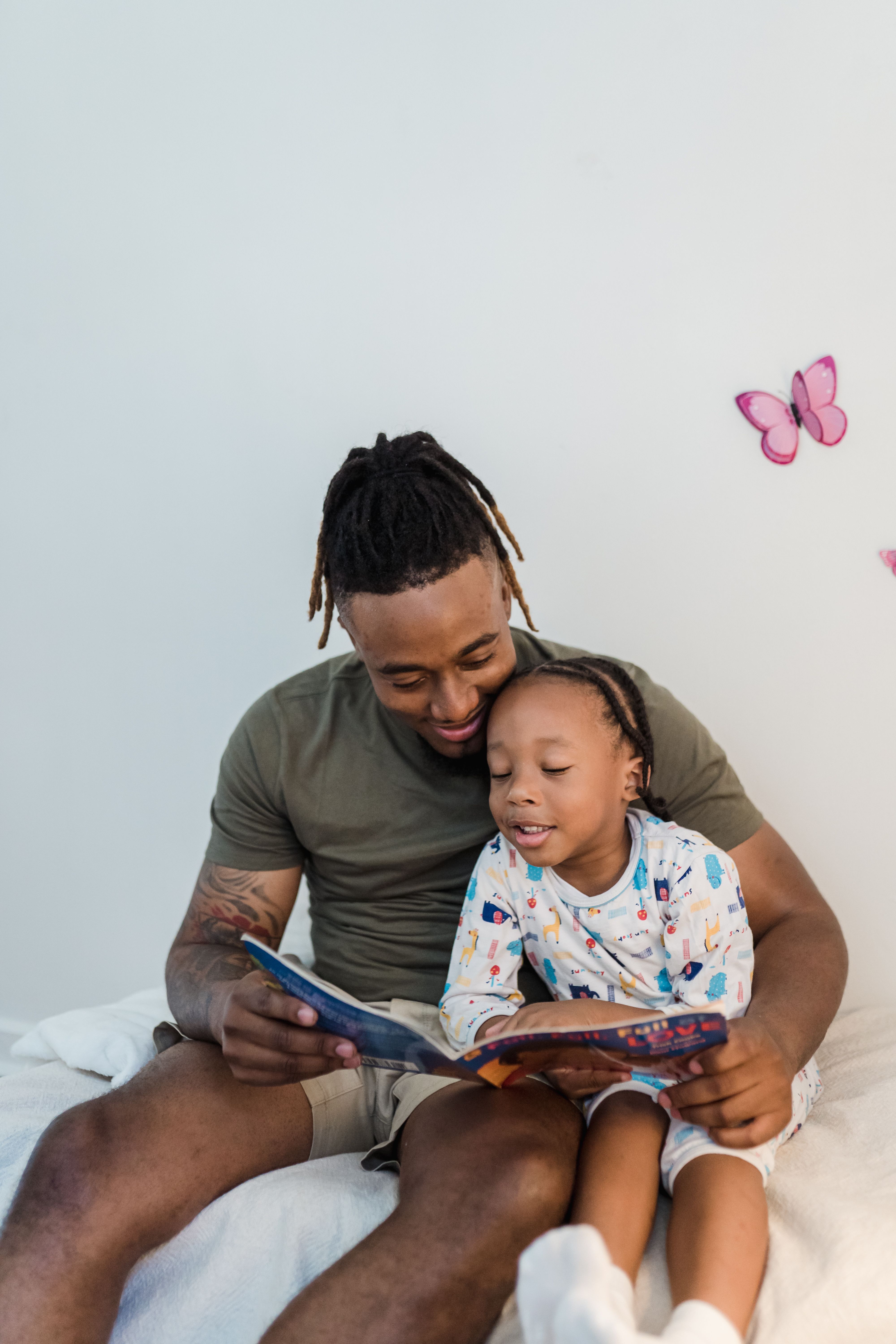 A loving father reading a book with his young son, creating a bonding moment indoors.