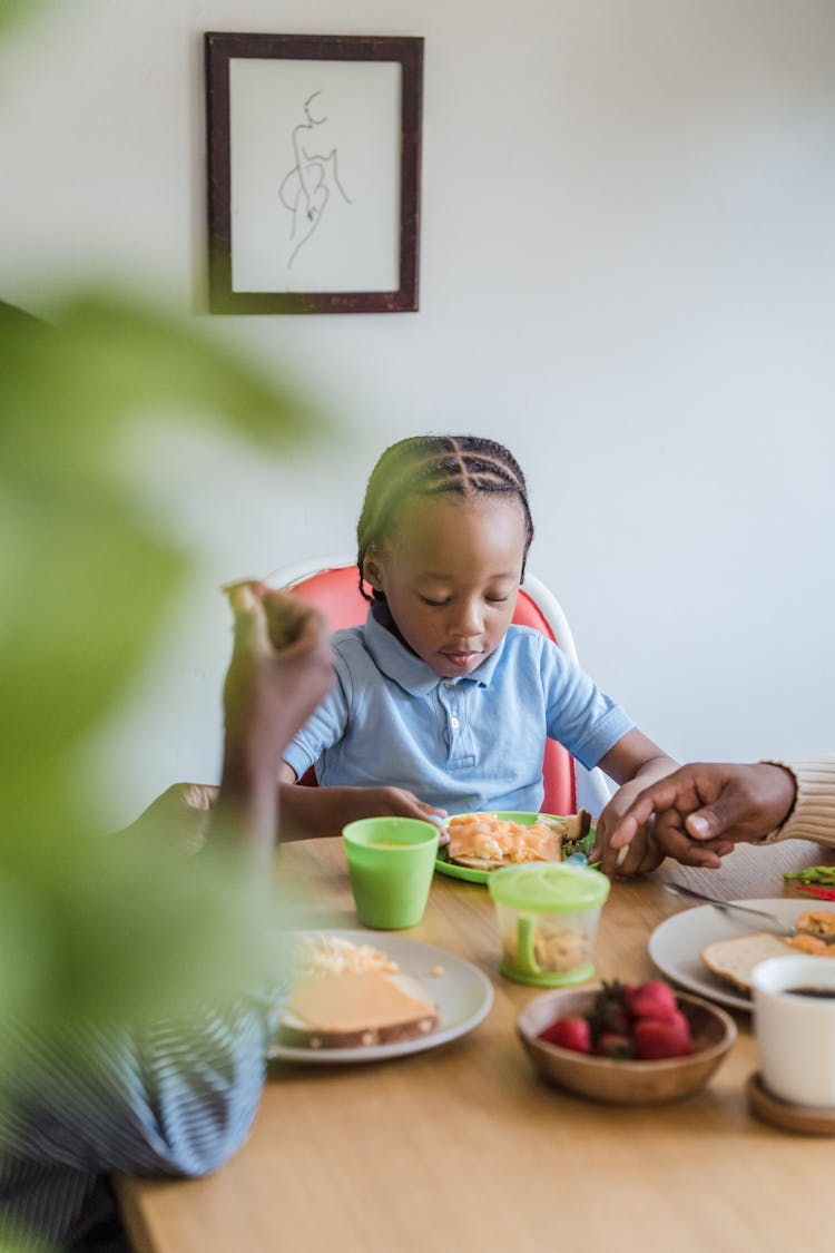 Little Girl Eating Breakfast At Table