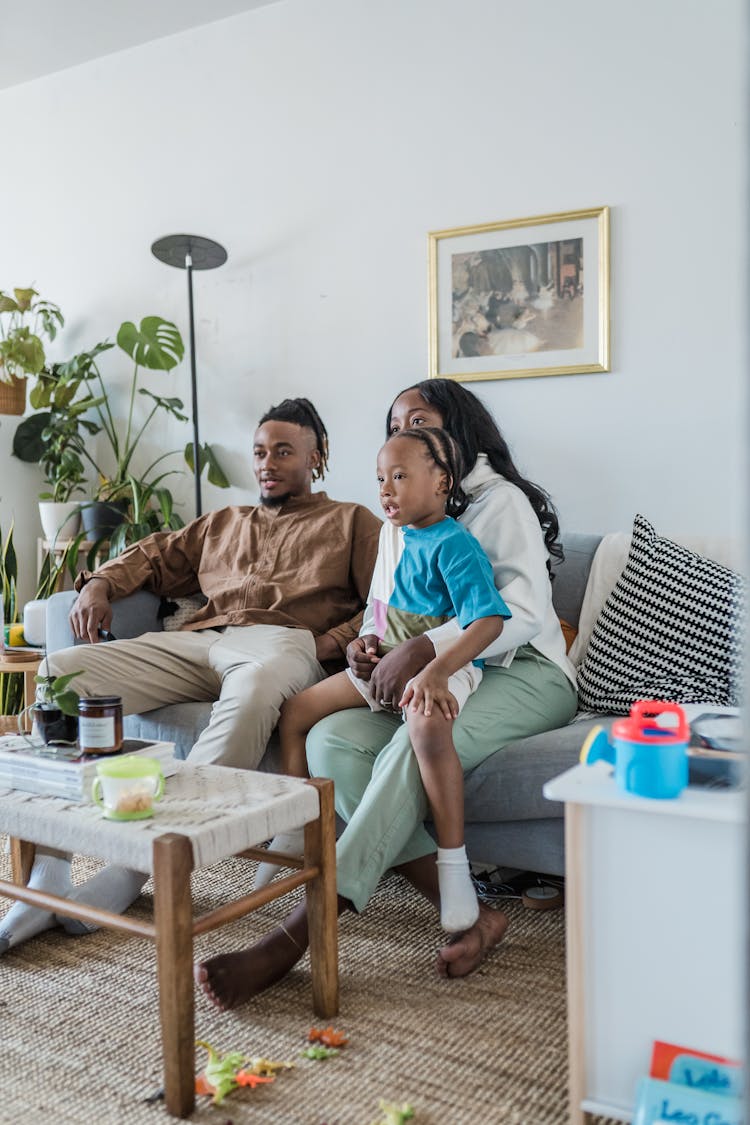 Family Watching TV On Couch