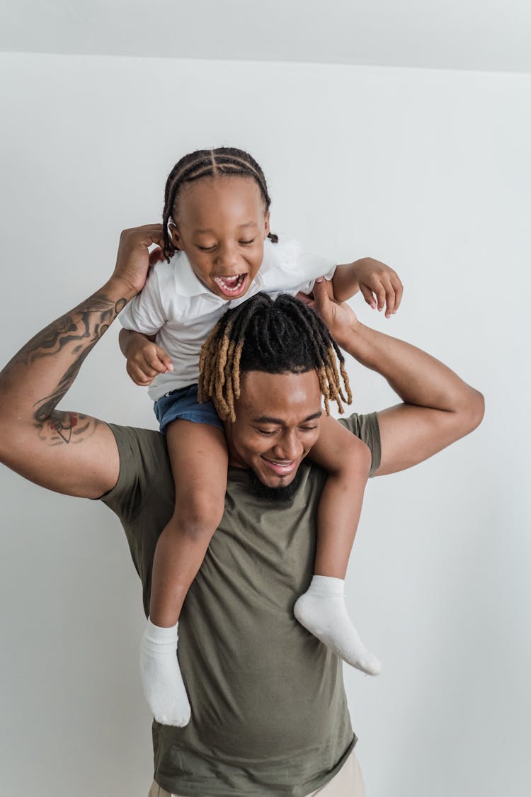 Happy Daughter Sitting On Father Shoulders