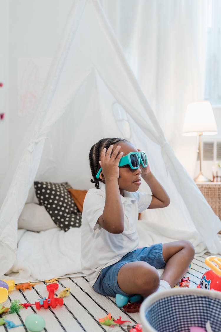 Little Girl Sitting On Floor With Sunglasses On