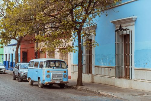 Free A vibrant street scene in Oaxaca, Mexico featuring a vintage Volkswagen van and colorful facades. Stock Photo
