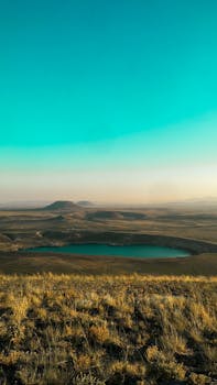 Captivating landscape of a serene lake surrounded by hills in Konya, Turkey under a blue sky.