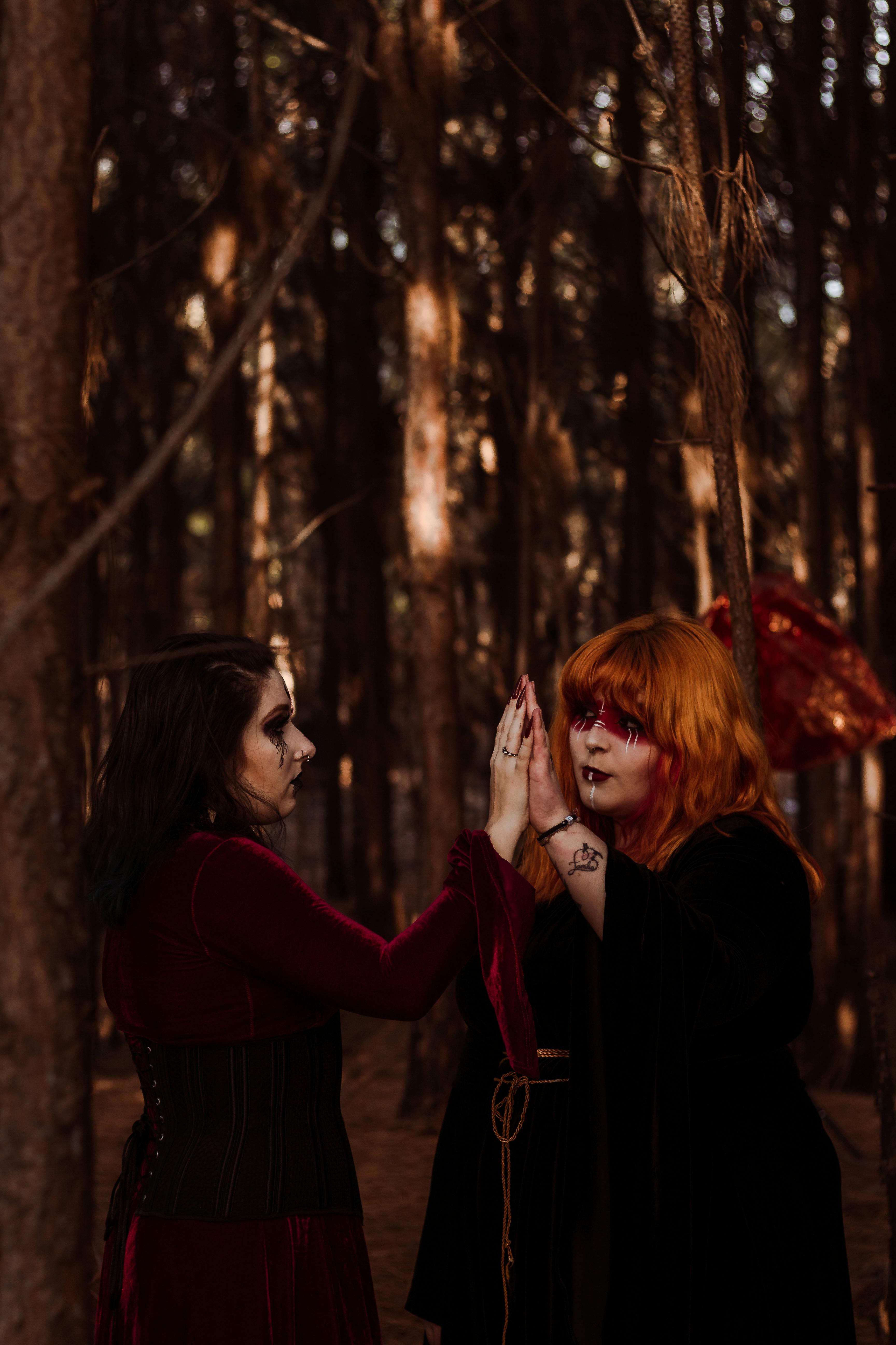 women in witch costumes in the forest