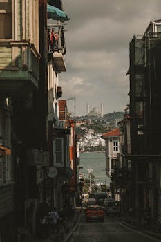 A picturesque street in Istanbul leads to a view of the Bosphorus and distant mosque spires.