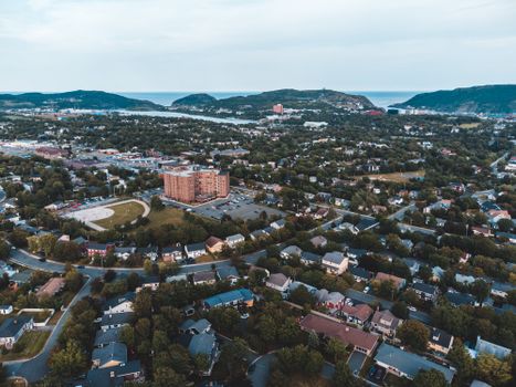 Stunning aerial view of a sprawling suburban neighborhood with greenery and distant mountains.
