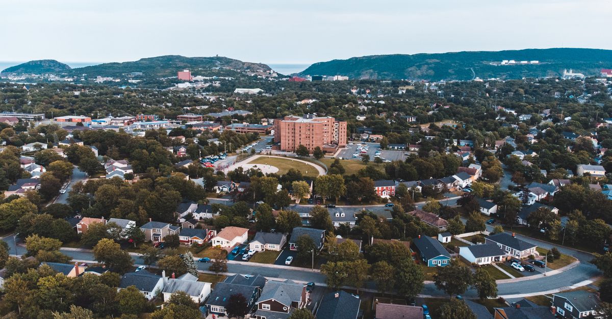 Aerial view of a suburban neighborhood surrounded by hills and greenery.