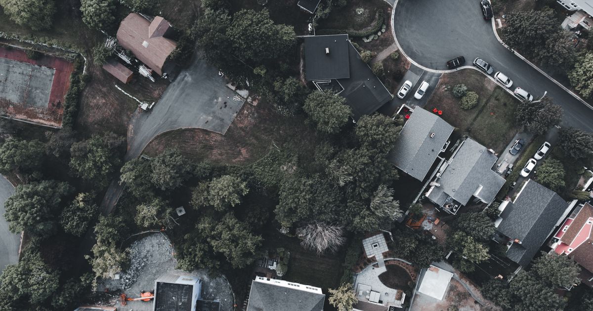 Aerial stock photo of a tree-lined suburban neighborhood, header for the Monmouth and Ocean County market update