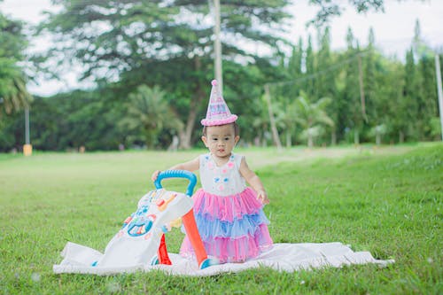 A Girl in a Dress Standing on Picnic Blanket