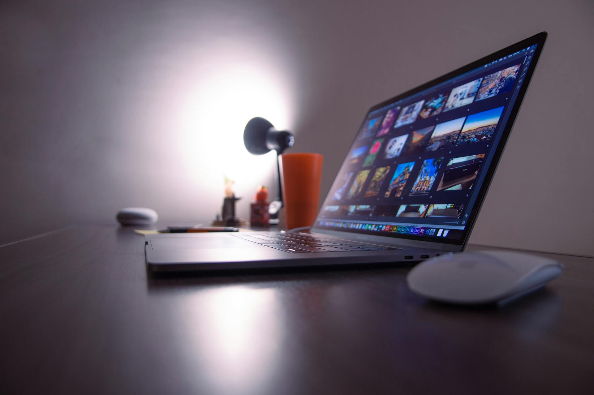 A sleek desk setup featuring a laptop, desk lamp, and accessories.