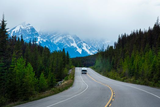 White Car on Road Near Green Trees and Mountain