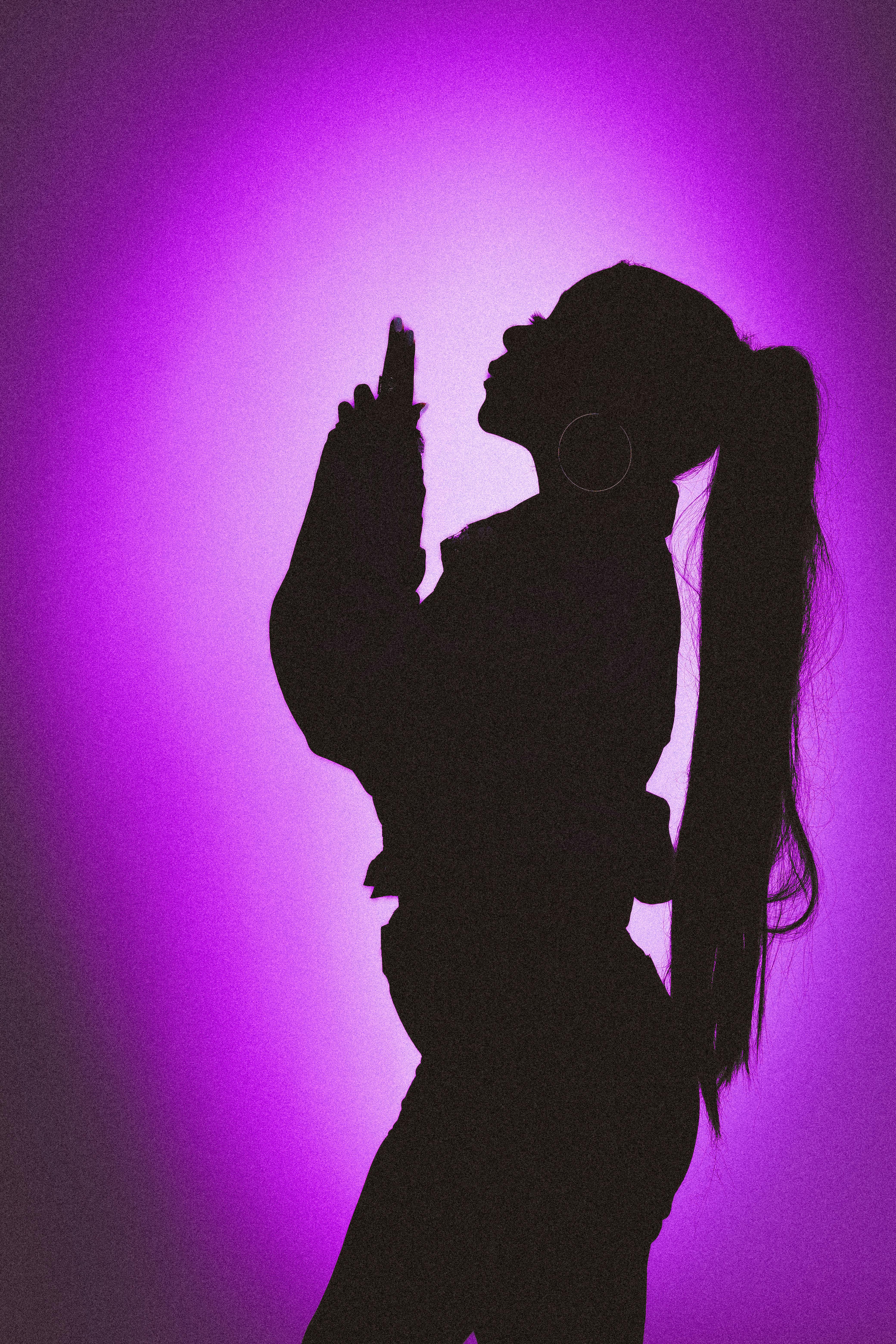 Silhouette of a woman posing against a vivid purple backdrop, creating a striking visual.