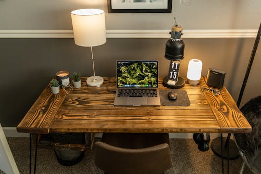 Stylish home office setup with laptop and decor on a wooden desk. Functional and cozy workspace.