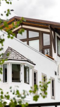 Close-up view of a modern house exterior showcasing large windows and architectural detail.