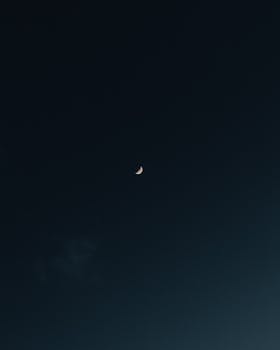 Capture of a crescent moon in a serene night sky, showcasing tranquil lunar beauty.