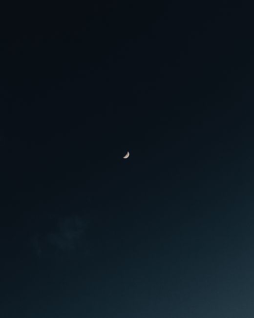 Capture of a crescent moon in a serene night sky, showcasing tranquil lunar beauty.