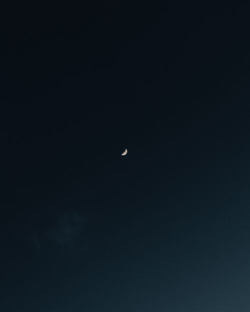 Free Capture of a crescent moon in a serene night sky, showcasing tranquil lunar beauty. Stock Photo