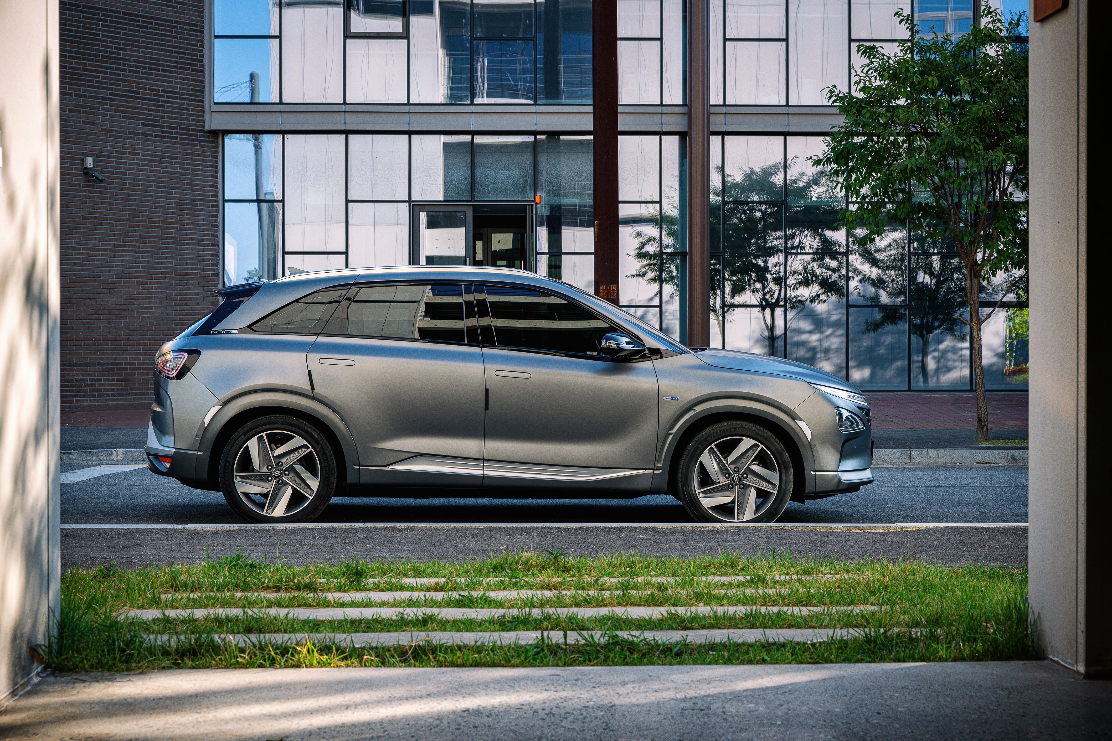 A Gray Hyundai Grandeur Parked Near the Glass Building · Free Stock Photo